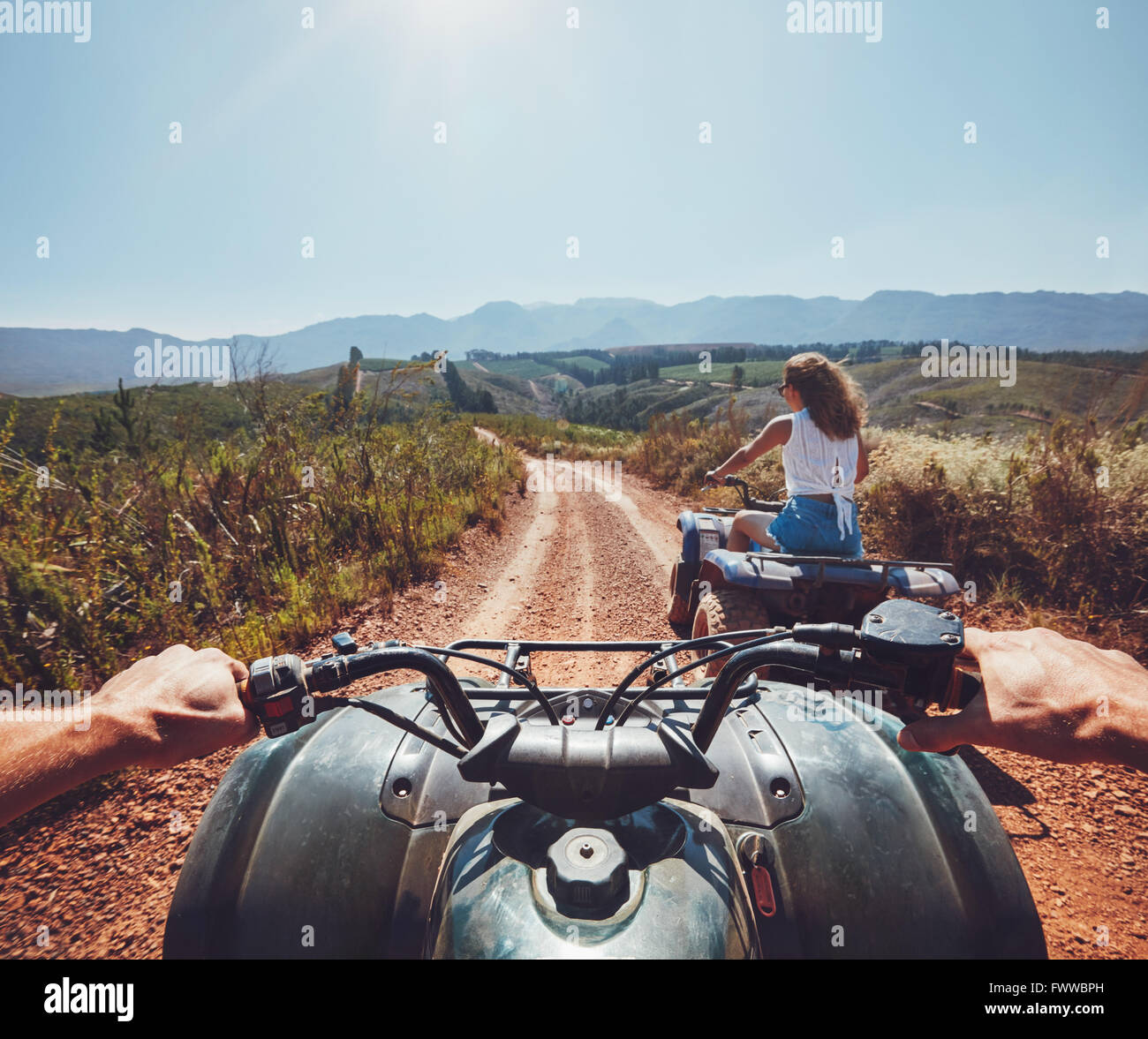 Young people on quad bikes on a countryside trail. View from a quad ...