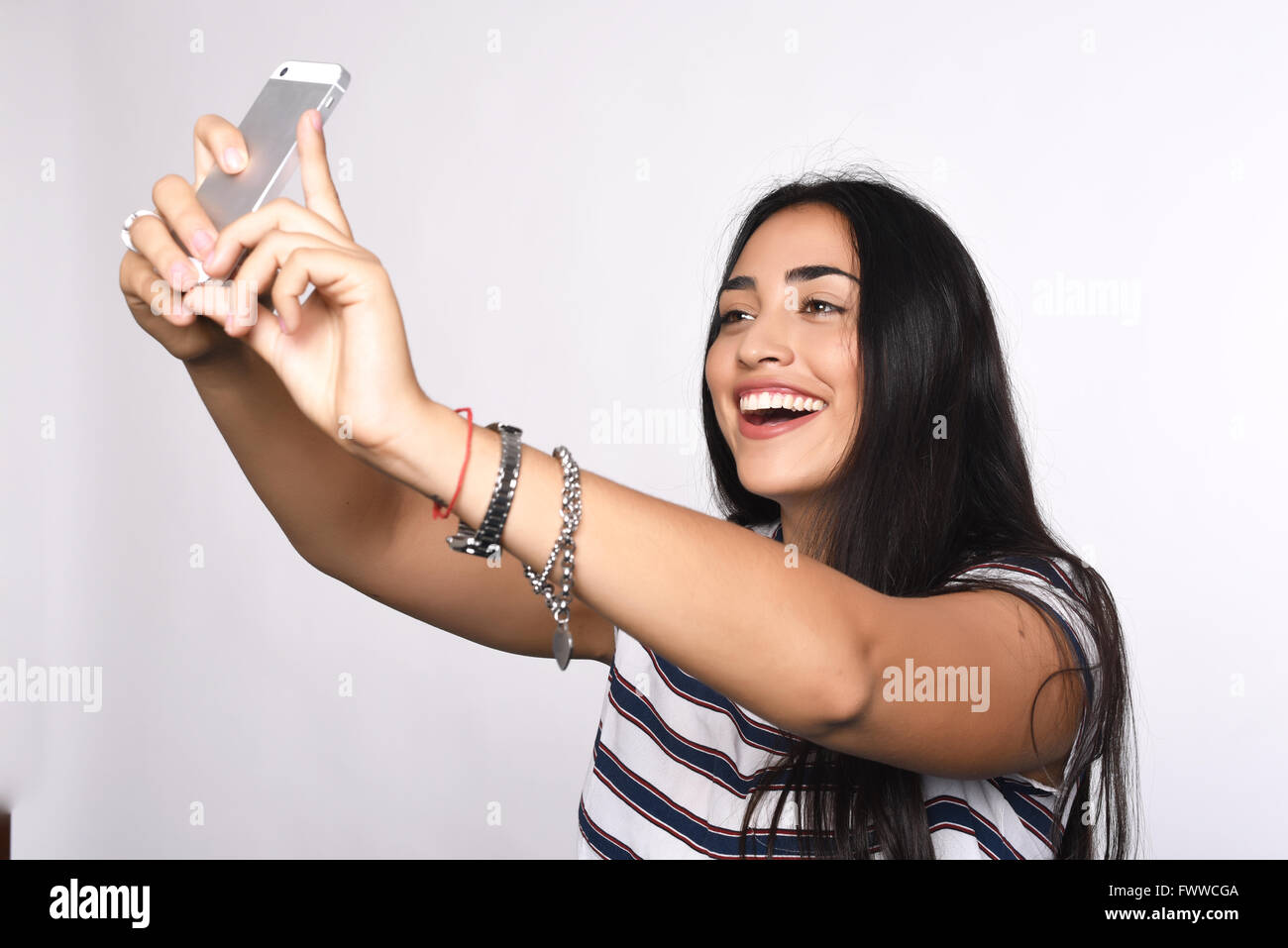 Young beautiful woman taking selfie with smartphone indoor. Isolated ...
