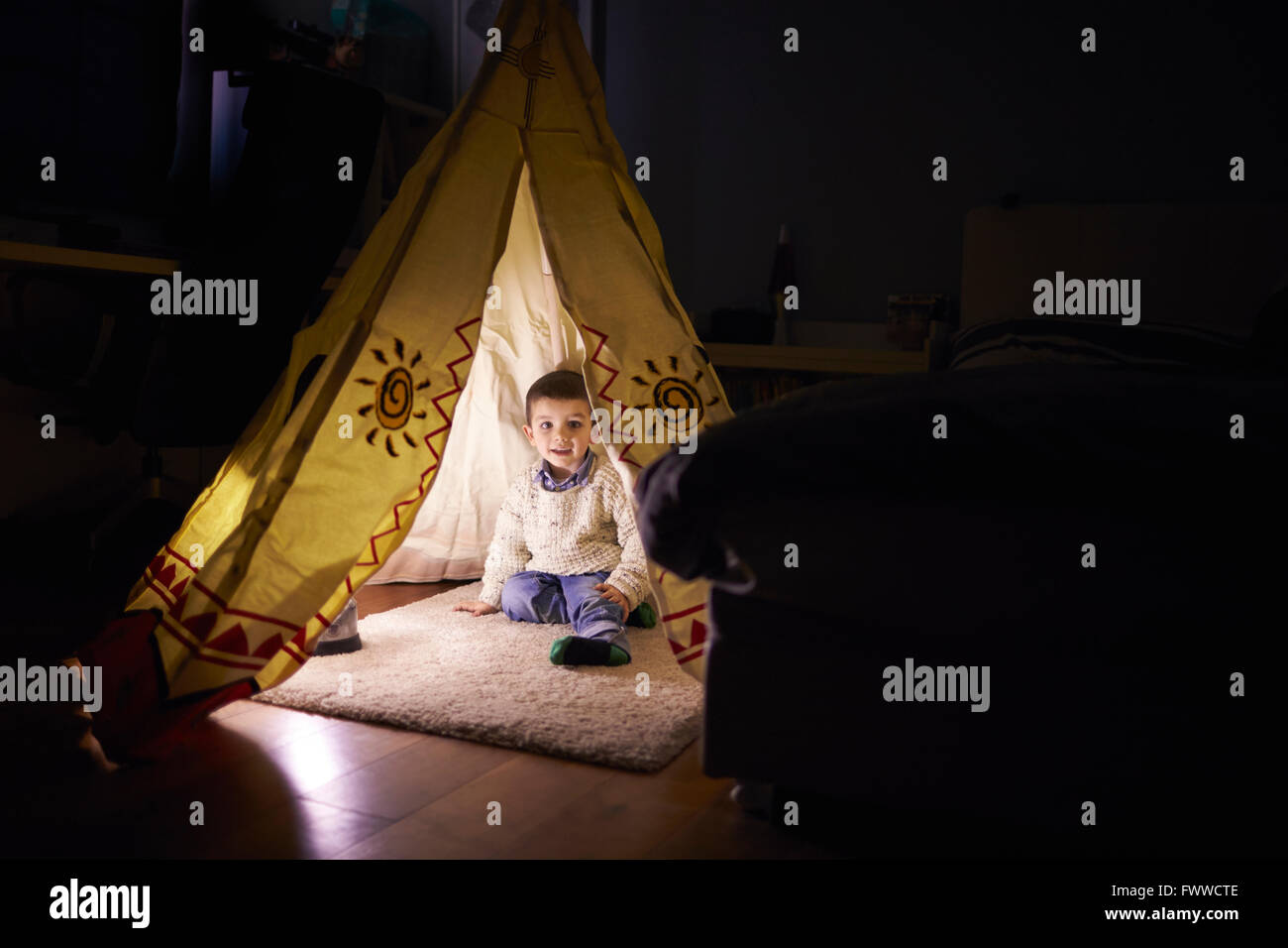 Young Boy Playing Inside Tent Set Up Indoors Stock Photo
