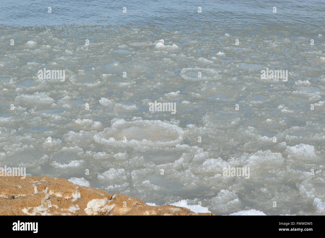 Ice and snow beginning to melt along the coast of Lake Huron in the early Spring Stock Photo