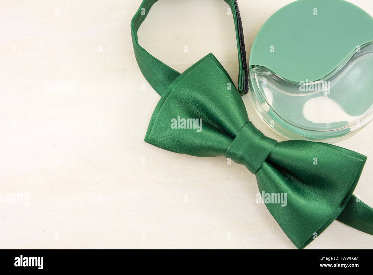 Green Bow tie and parfume  on a wooden table Stock Photo
