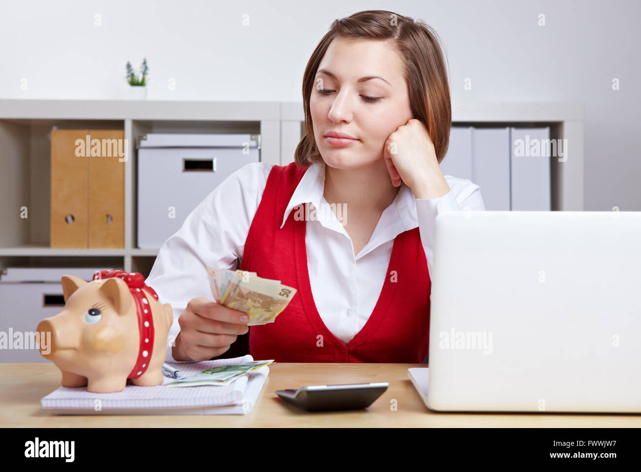 Pensive business woman with Euro money and piggy bank in office Stock ...