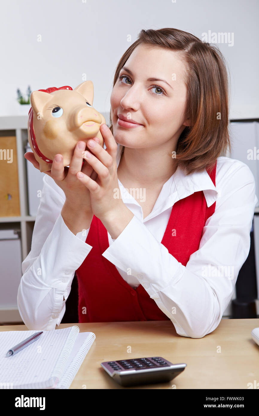 Attractive smiling business woman with piggy bank at her desk Stock ...