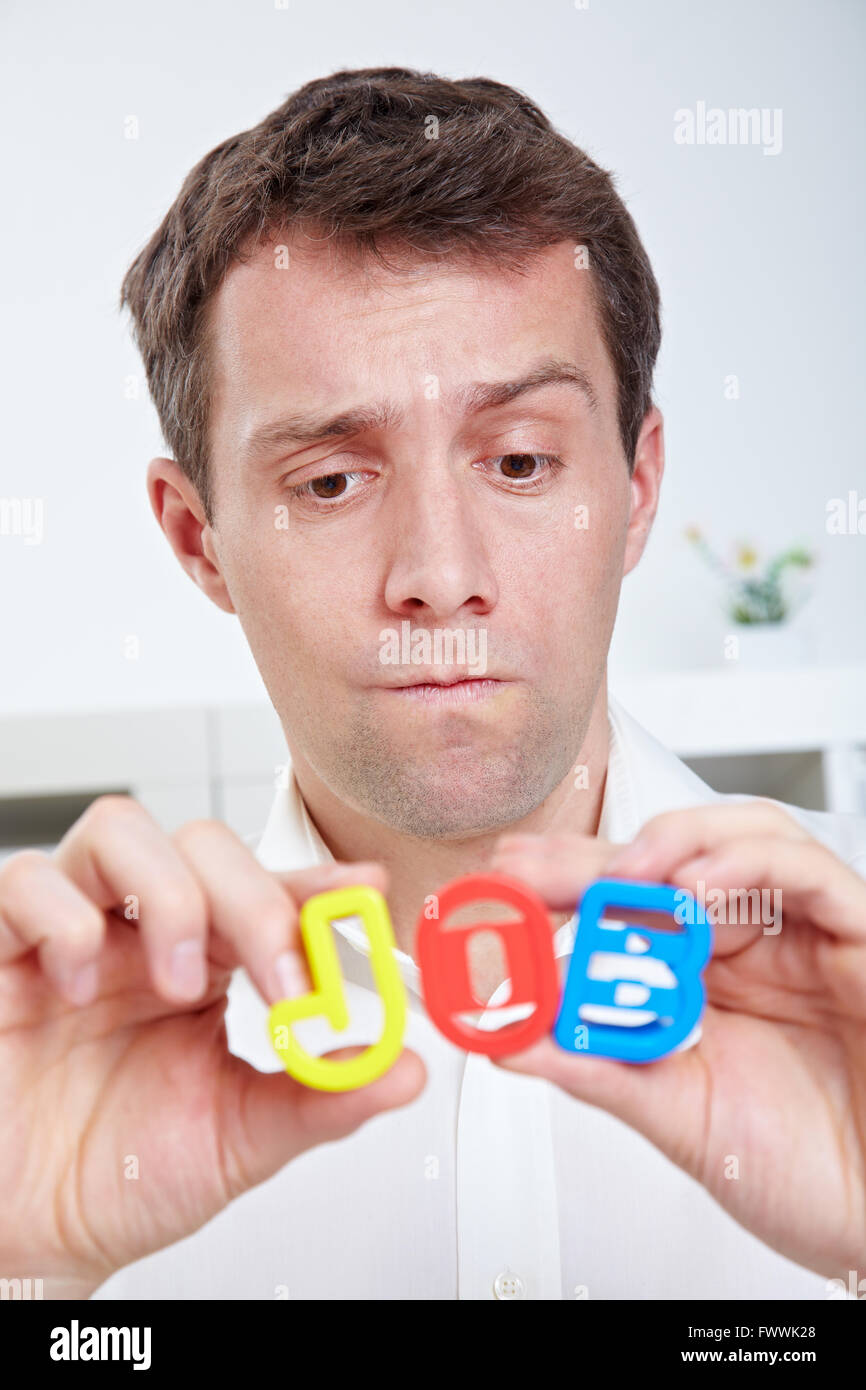 Pensive business man looking at word JOB in his hands Stock Photo