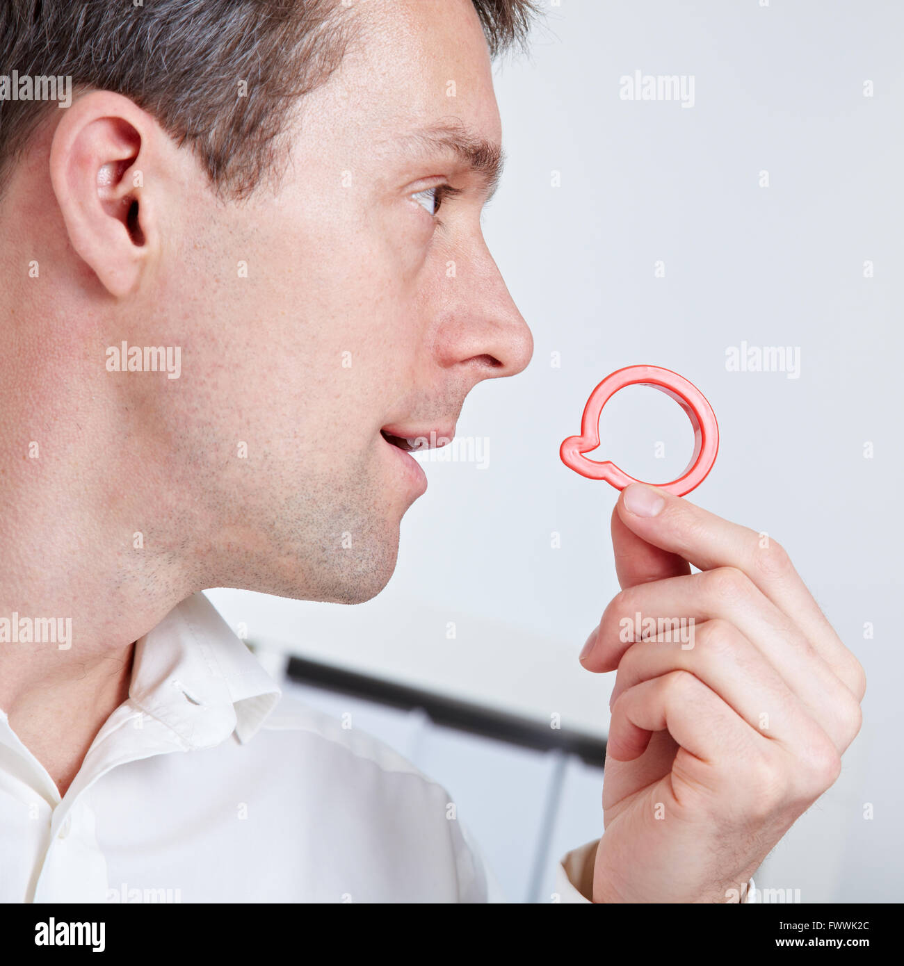 Business man holding speech balloon symbol near his mouth Stock Photo
