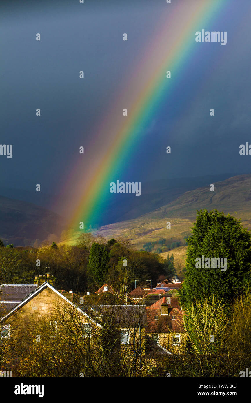 Rainbow over Scottish Village of Lennoxtown showing village church and Campsies in background Stock Photo