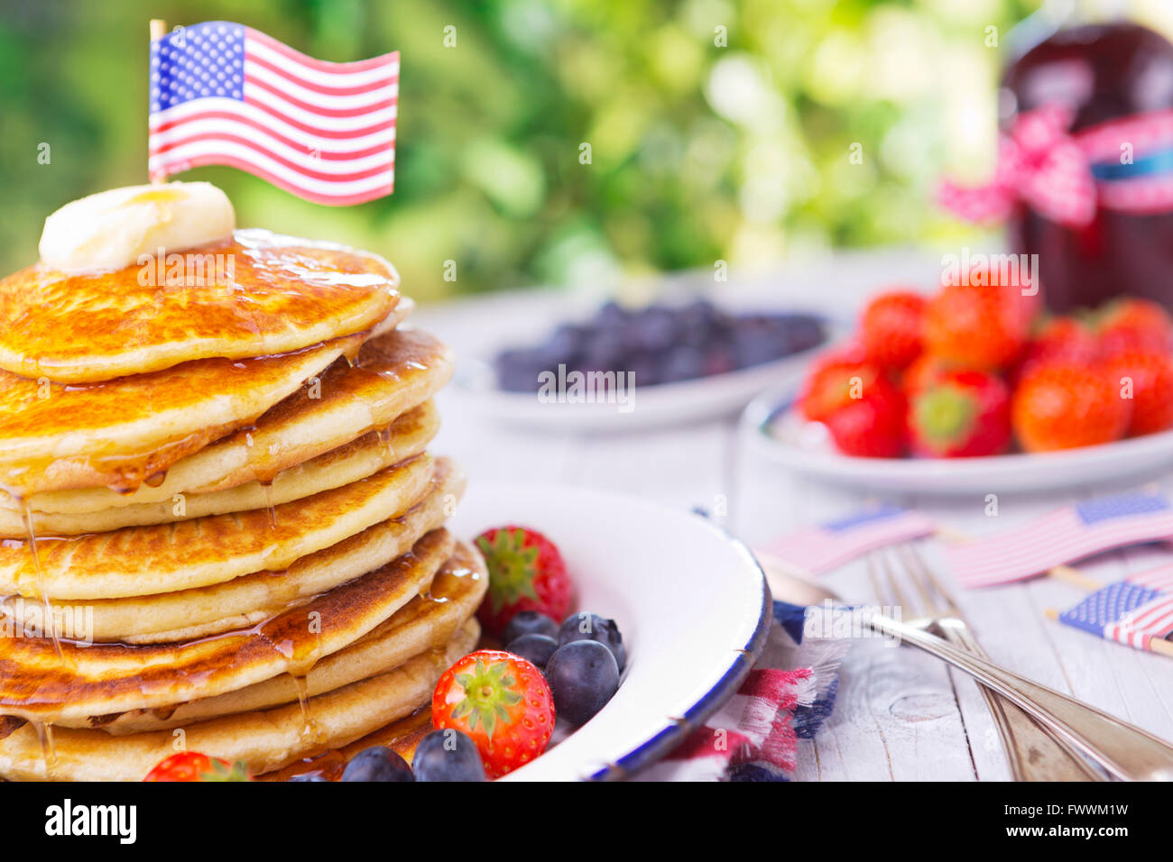 A stack of homemade pancakes with fresh fruit, butter and syrup. Stock Photo