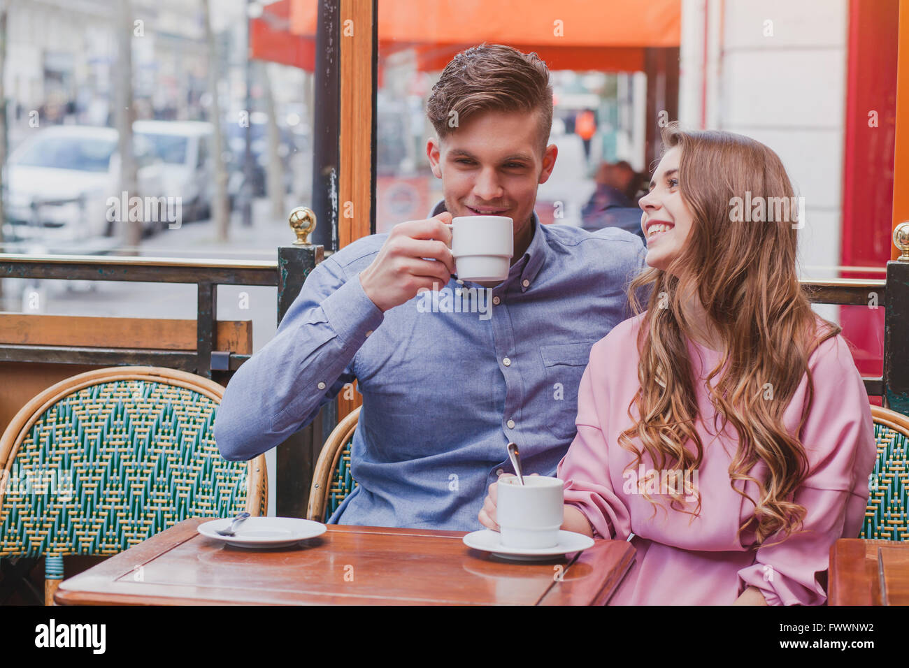 young happy couple drinking coffee and laughing in cafe in Europe, dating, good positive moments Stock Photo