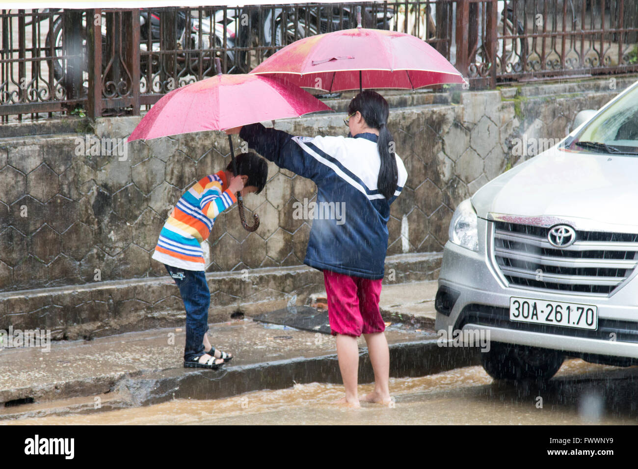 Mother and young daughter sheltering from heavy rains in Sapa, north ...