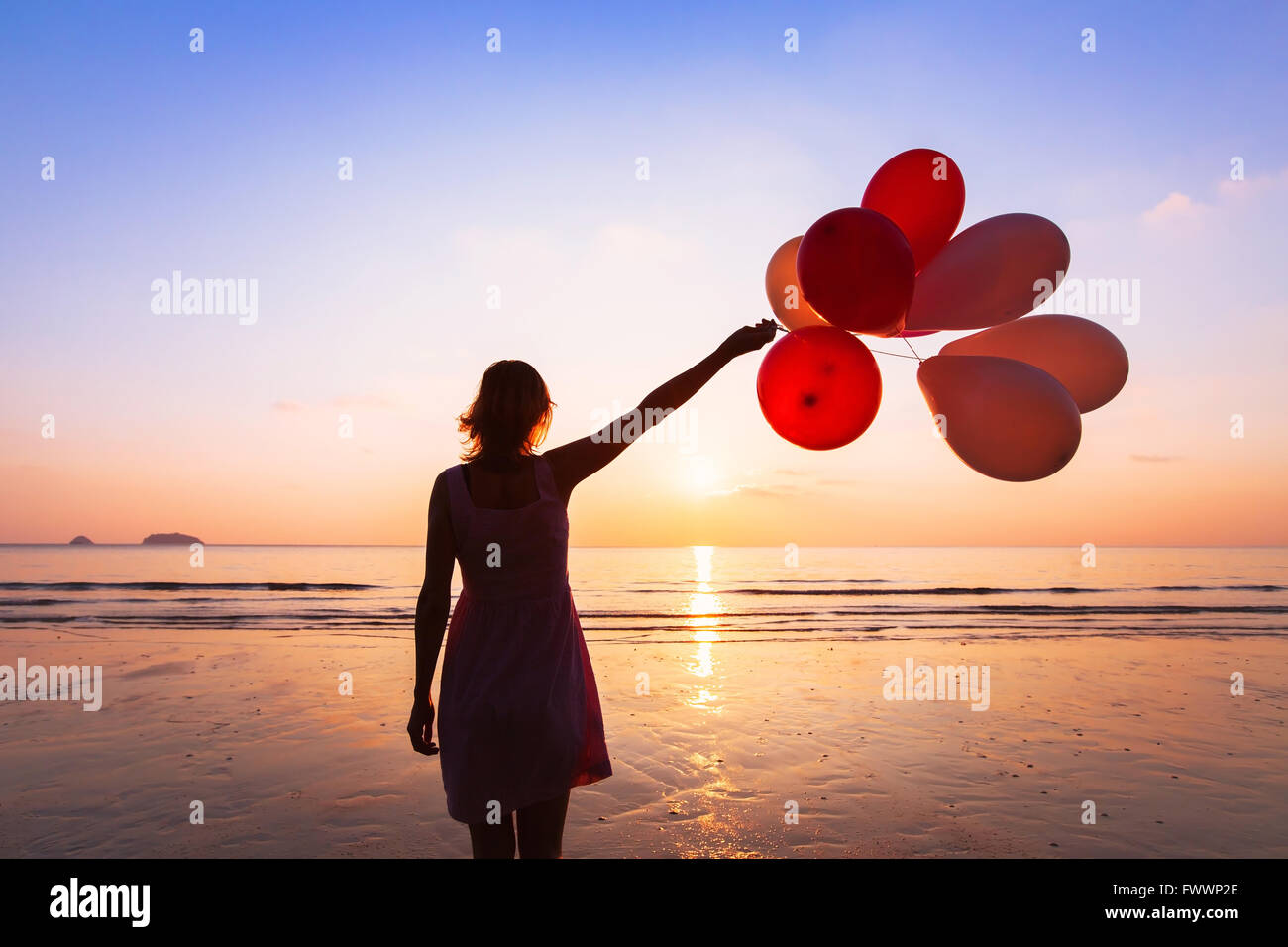 imagination and creativity, girl with multicolored balloons at sunset with copyspace, inspiration concept Stock Photo