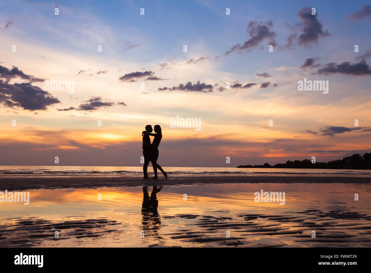 silhouette of couple on sunset beach, beautiful background about love and relationships, man and woman Stock Photo