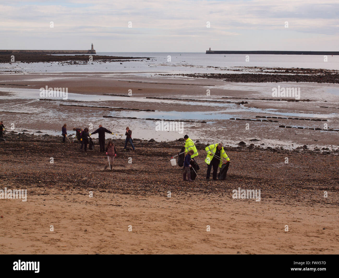 Newcastle Upon Tyne, 8th April 2016, UK News. Marine Conservation volunteers removing debris off the seashore in a sponsored litter pick to help protect the marine life at Tynemouth. This Northumberland Wildlife Trust Event was sponsored by the 'Peoples Postcode Lottery' as part of the trusts regular marine conservation programme, with the collaboration of Engie P.F.I. Managers for Newcastle and Gateshead schools, attired in high visibility jackets. Helping to clear the beaches of plastic and harmful debris from entering the marine food chain as creatures feed.  Credit:  james walsh/Alamy Live Stock Photo