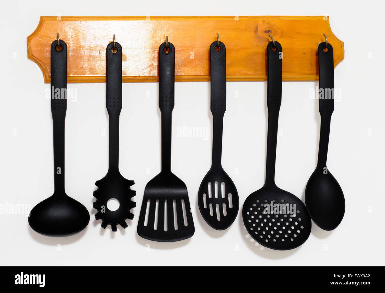 https://c8.alamy.com/comp/FWX9A2/kitchen-utensils-hanging-on-the-wall-with-white-background-FWX9A2.jpg