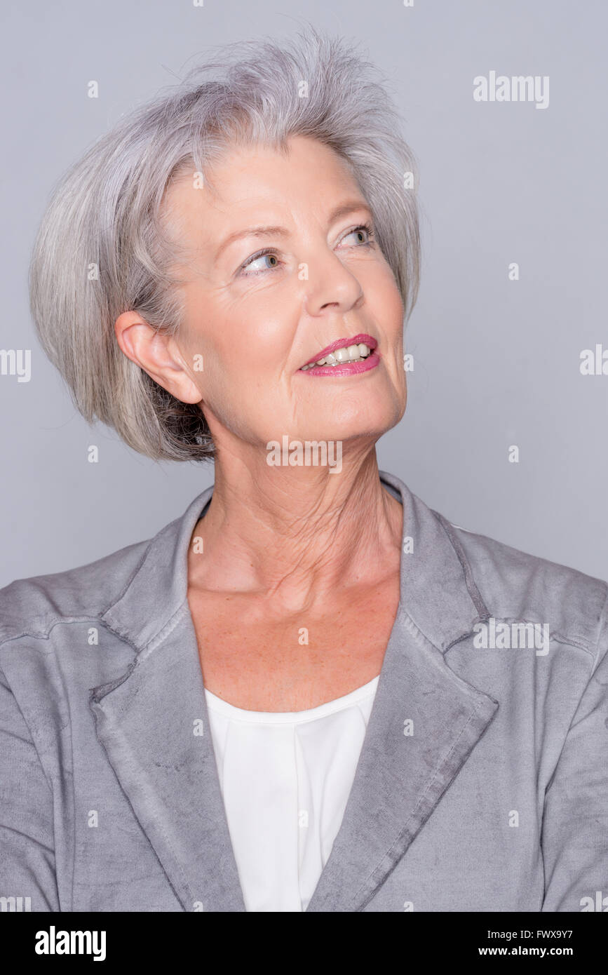Portrait of a smiling senior woman in front of gray background Stock ...