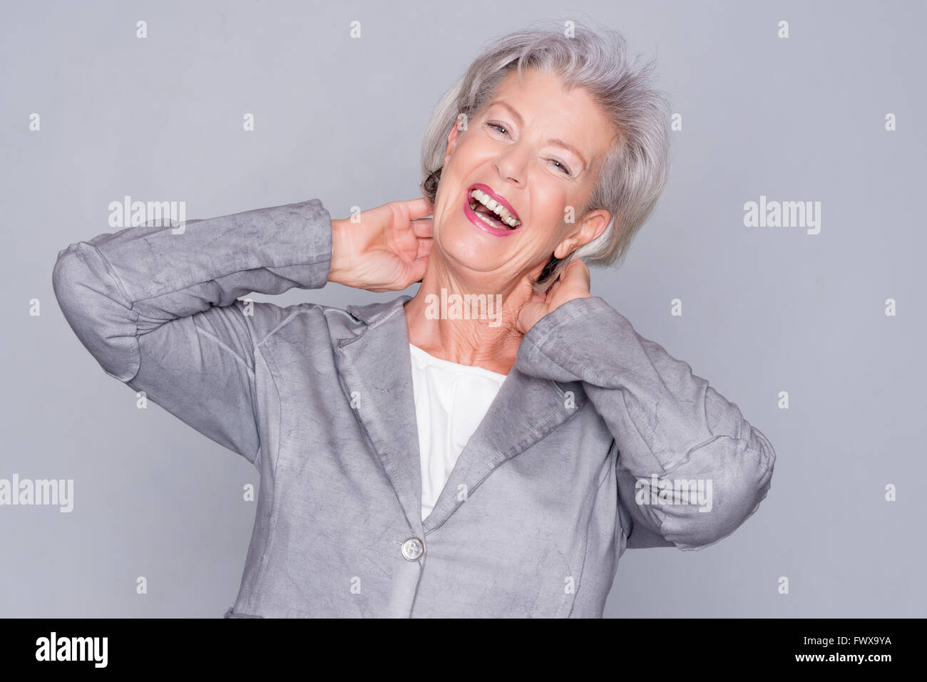Portrait of a smiling senior woman in front of gray background Stock ...