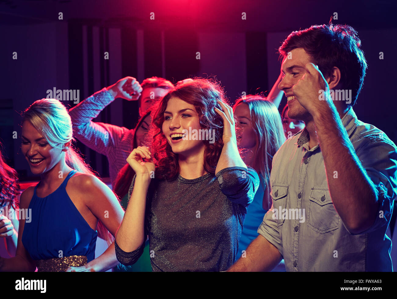 group of happy friends dancing in night club Stock Photo