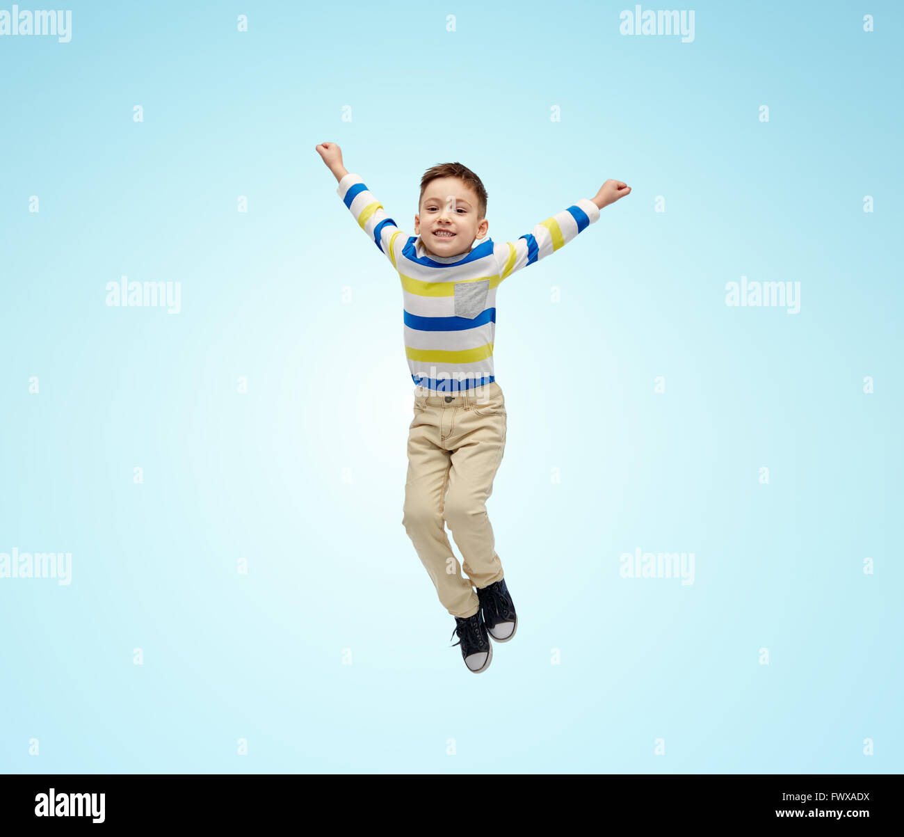 happy little boy jumping in air over blue Stock Photo - Alamy