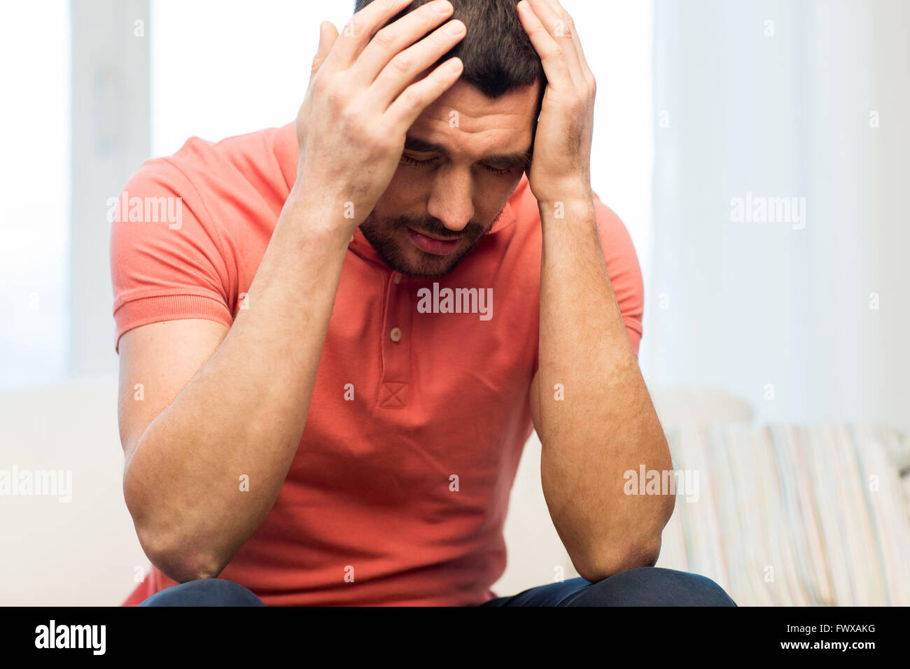 unhappy man suffering from head ache at home Stock Photo - Alamy
