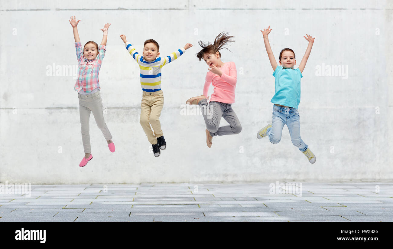 happy little girl jumping in air on street Stock Photo - Alamy