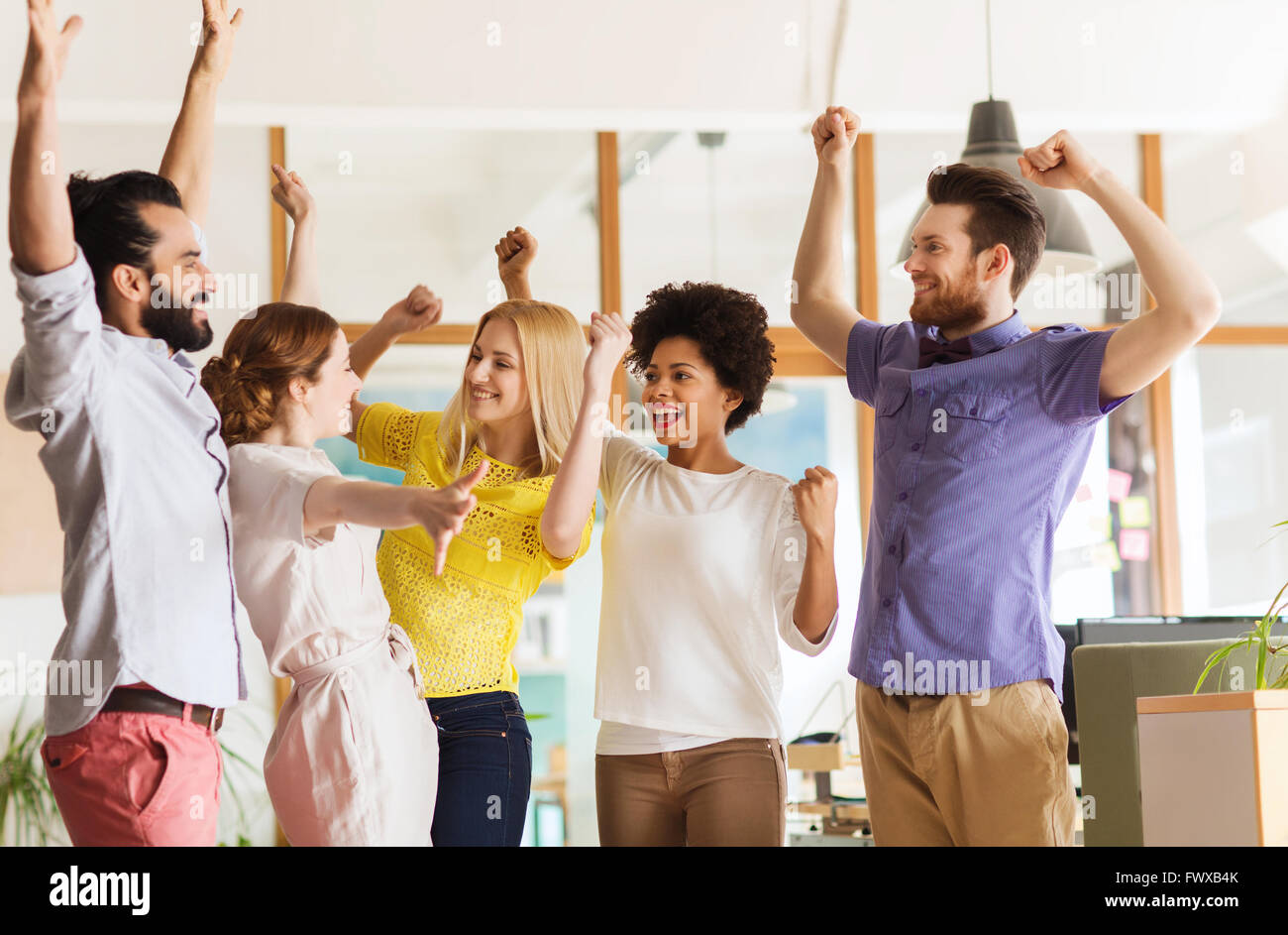 happy creative team celebrating victory in office Stock Photo - Alamy