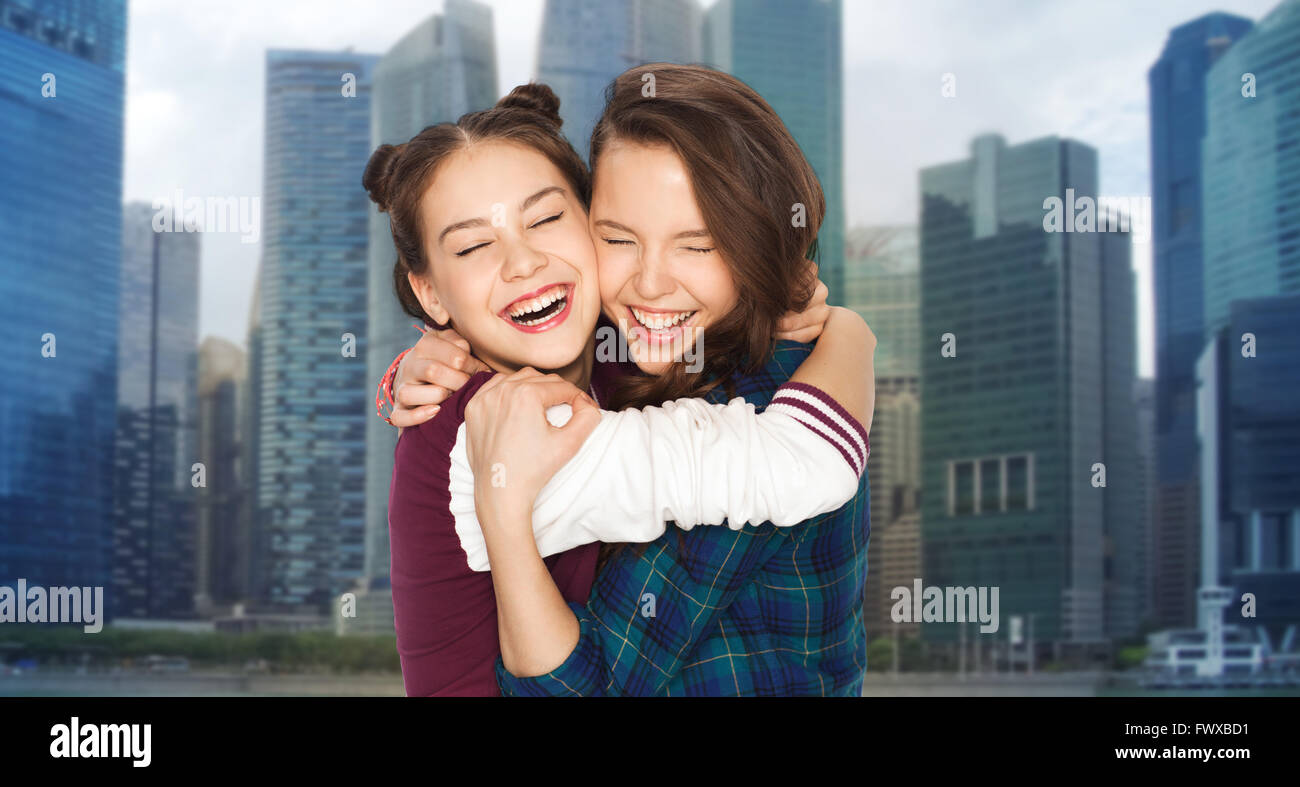 happy smiling teenage girls hugging over city Stock Photo - Alamy