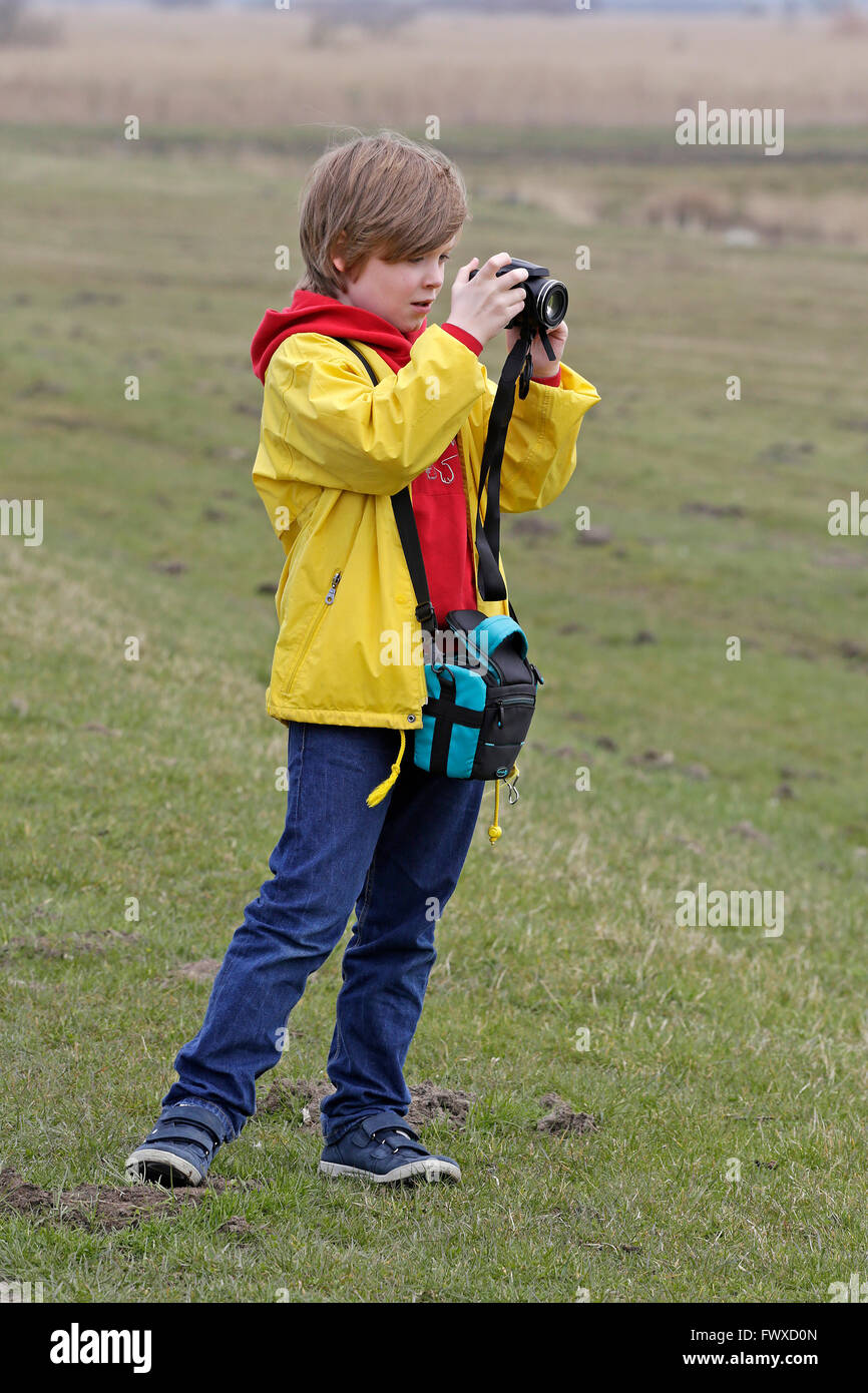 young boy taking photographs, East Friesland, Lower Saxony, Germany Stock Photo