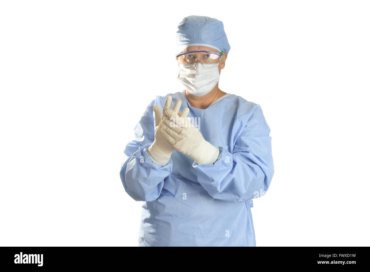 Surgical technician with safety glasses, mask, and surgical gloves on white background. Stock Photo