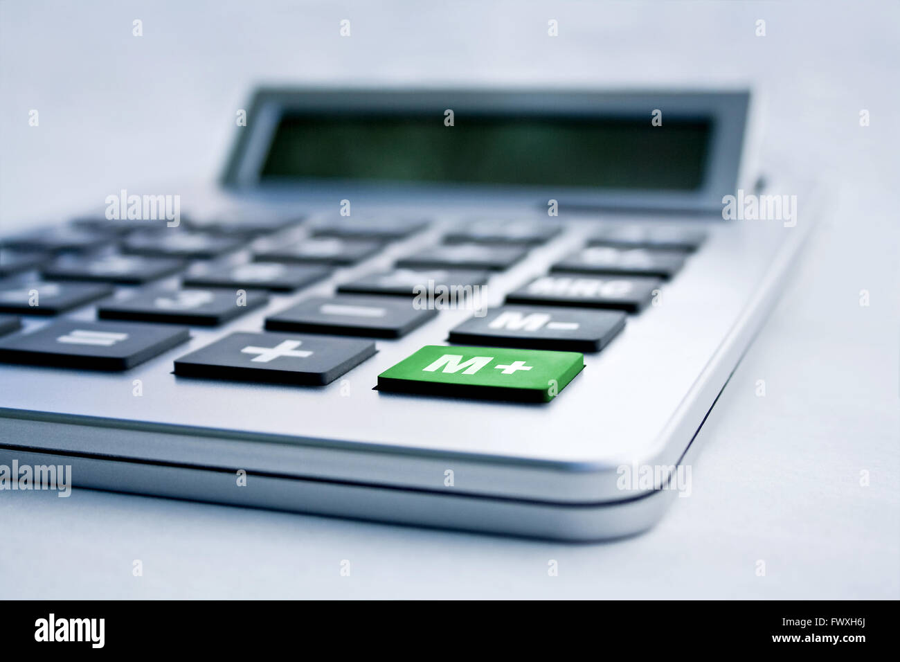 Calculator close up with a green M+ button Stock Photo - Alamy