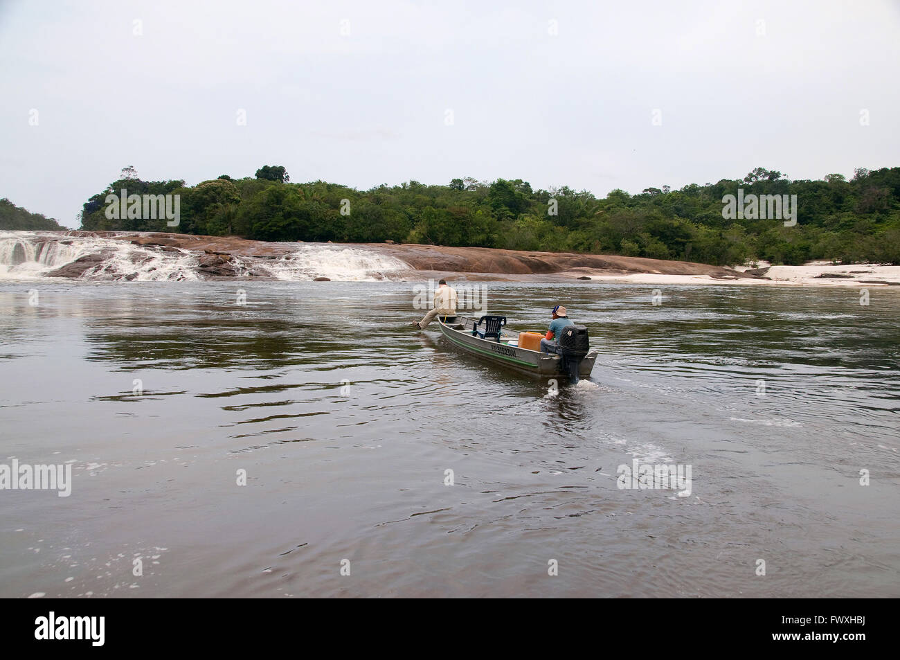 An angler in search of giant payara Dracula fish casts to a waterfall off Colombia's Cano Bocon River on the Llanos. Stock Photo