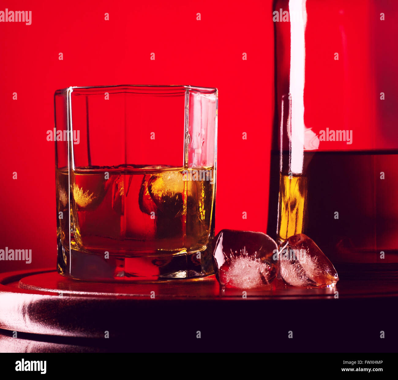 glass and bottle of whiskey on a red background Stock Photo - Alamy