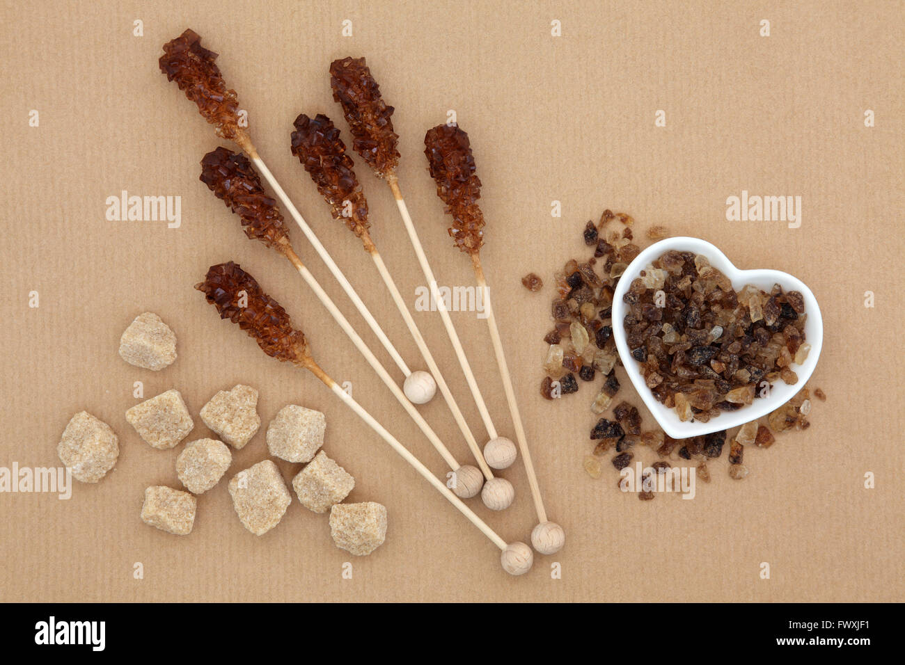 Sugar Chunks Brown sugar cubes, lollipops and crystal chunks over brown paper ...