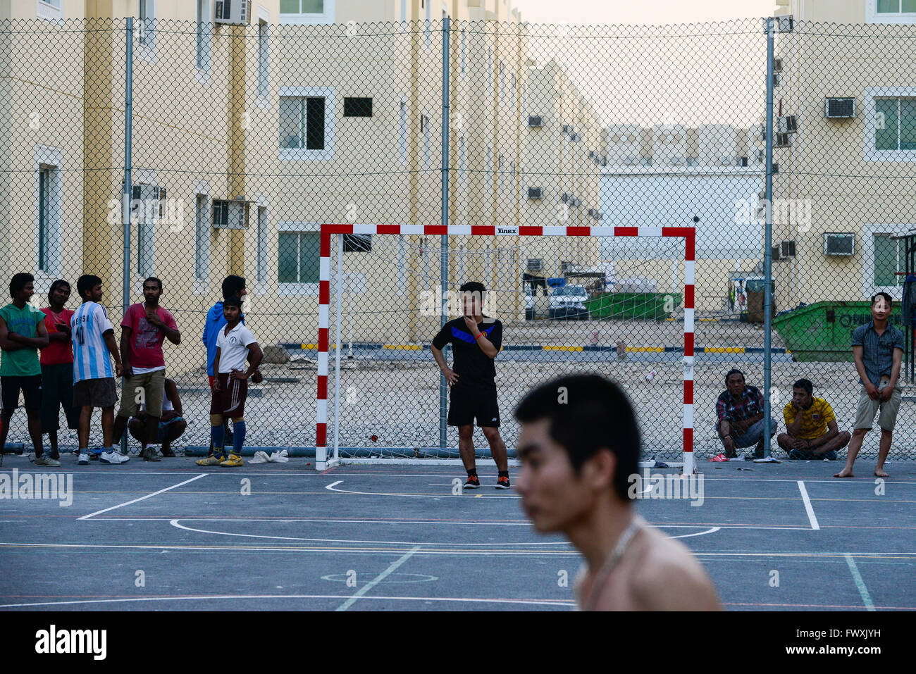 QATAR, Doha, industrial complex, housing camp for migrant worker outside the city, sports place, worker from Vietnam and Philippines play football at sports ground Stock Photo