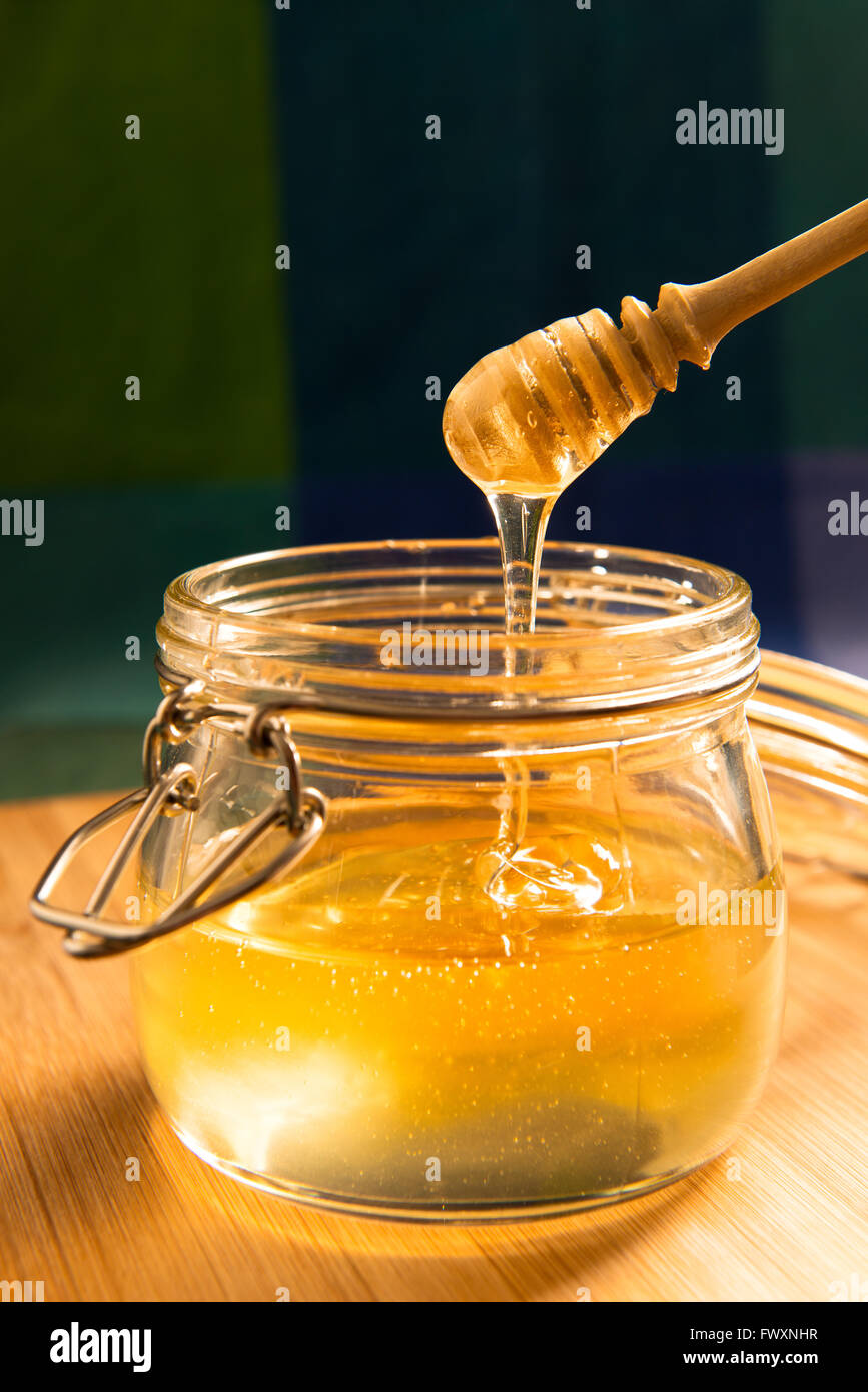 Acacia honey in a jar with honey stick Stock Photo Alamy