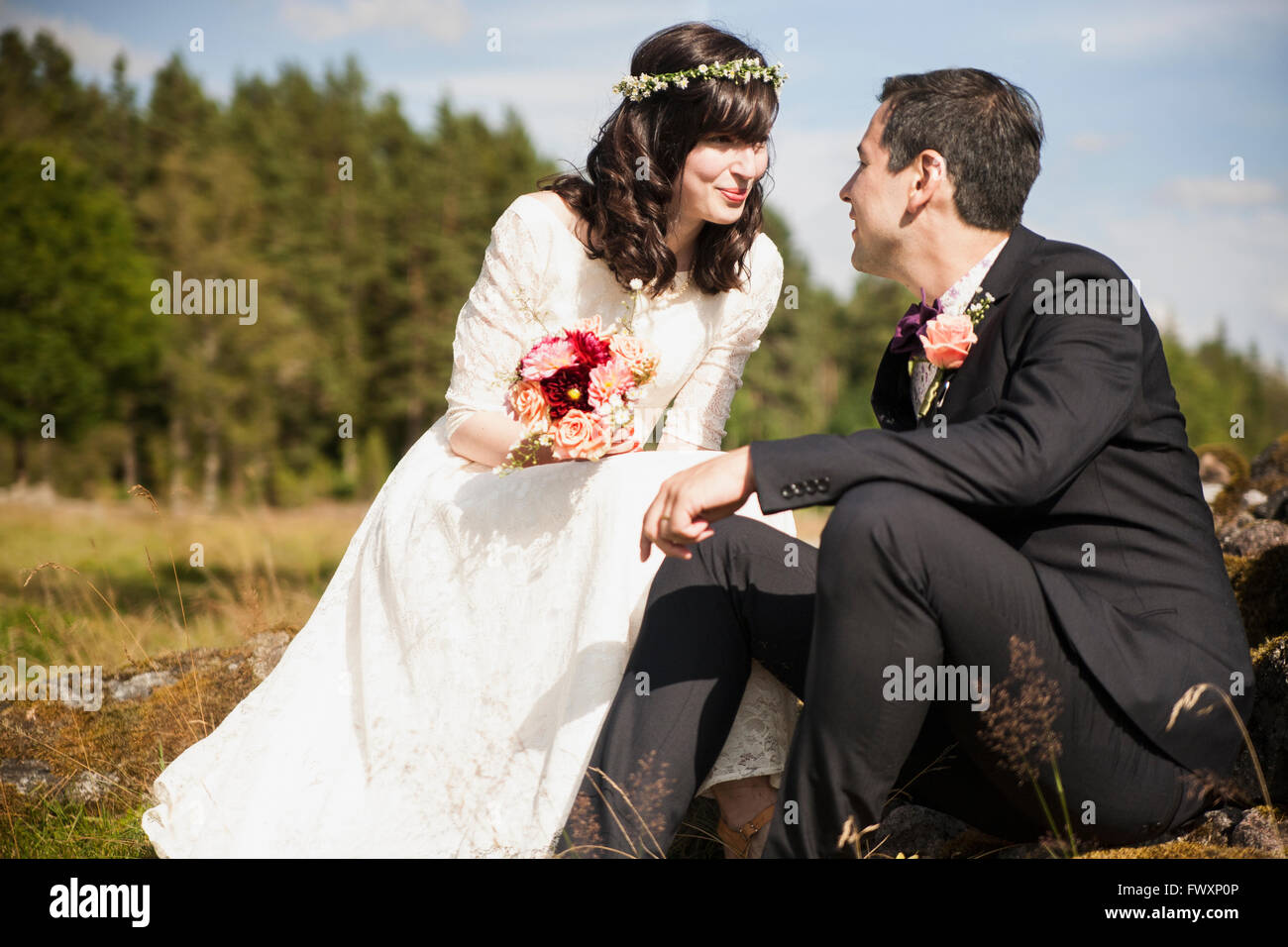 Sweden, Smaland, Vetlanda, Holsbybrunn, Newlyweds face to face in field Stock Photo