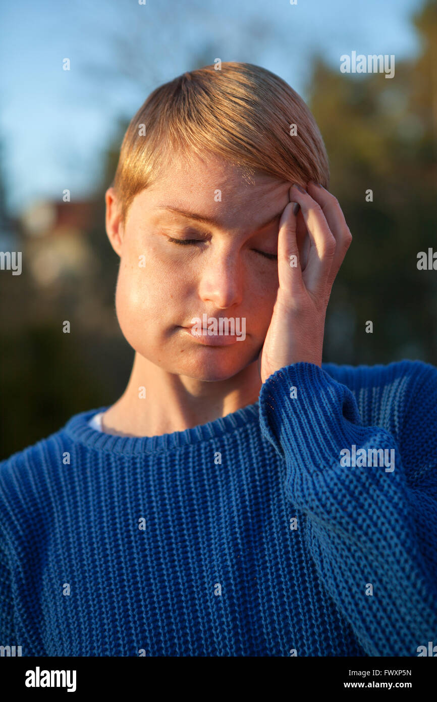 Sweden, Mid adult woman with eyes closed Stock Photo