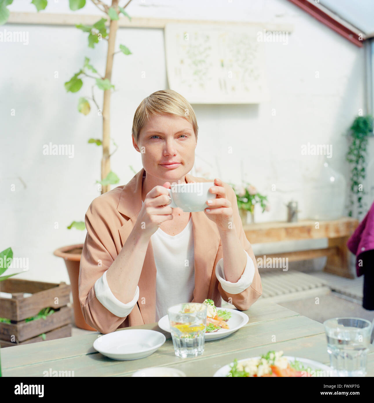 Sweden, Stockholm, Mid adult woman holding cup of coffee Stock Photo