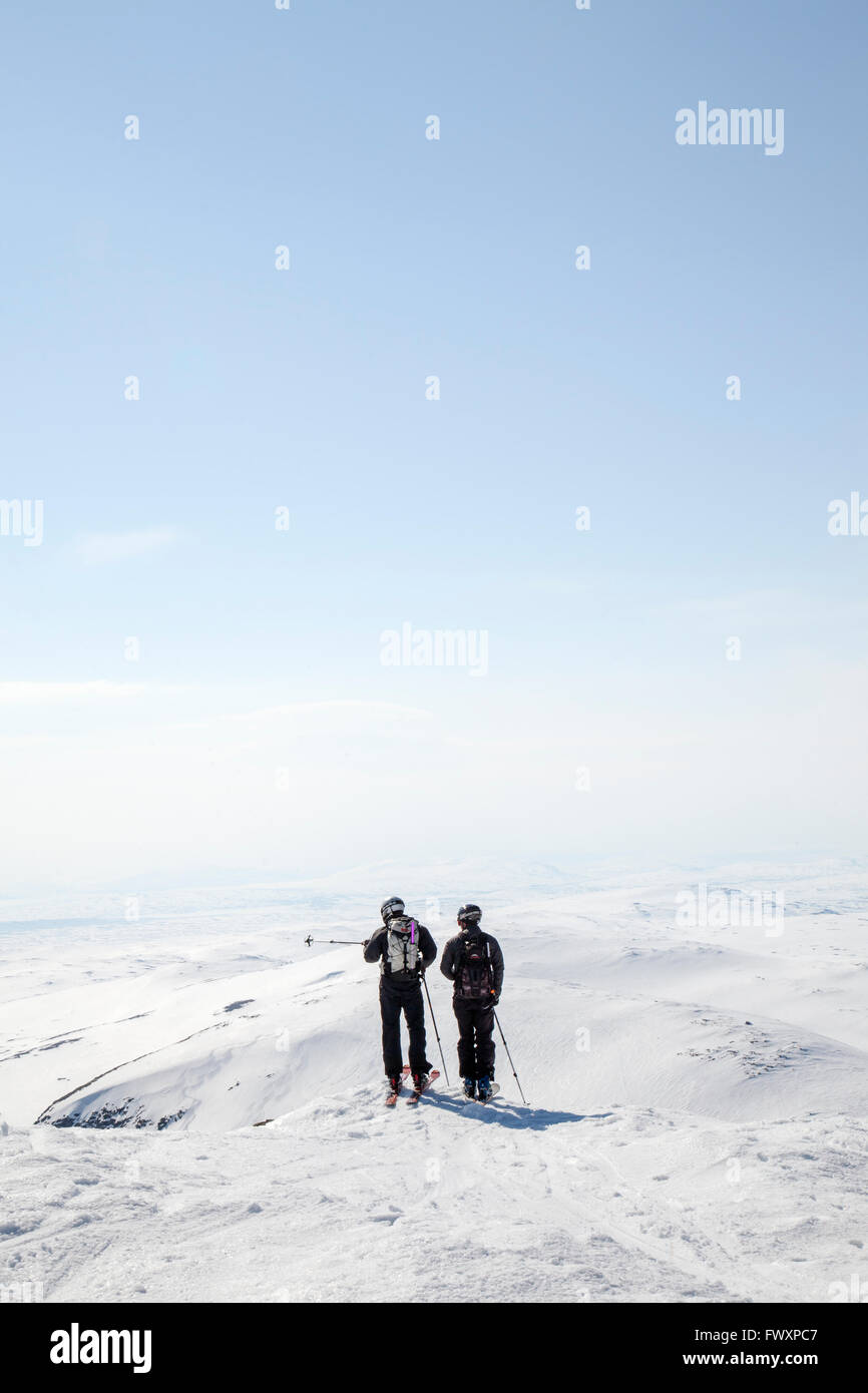 Sweden, Jamtland, Snasahogarna, Rear view of mid-adult men looking at mountains in winter Stock Photo