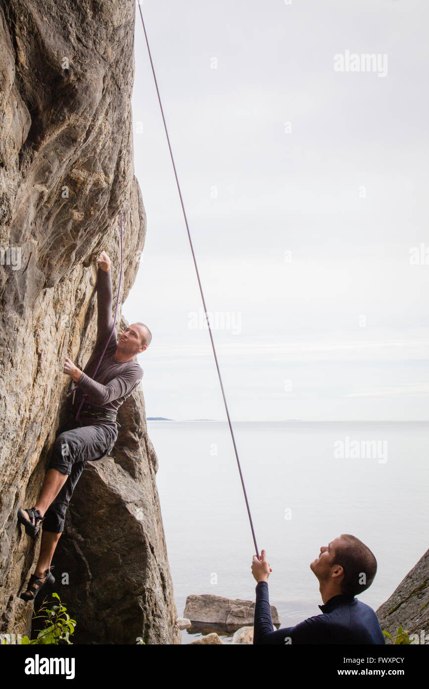 Sweden, Medelpad, Sundsvall, Essvik, Brattberget, Two men climbing cliff Stock Photo