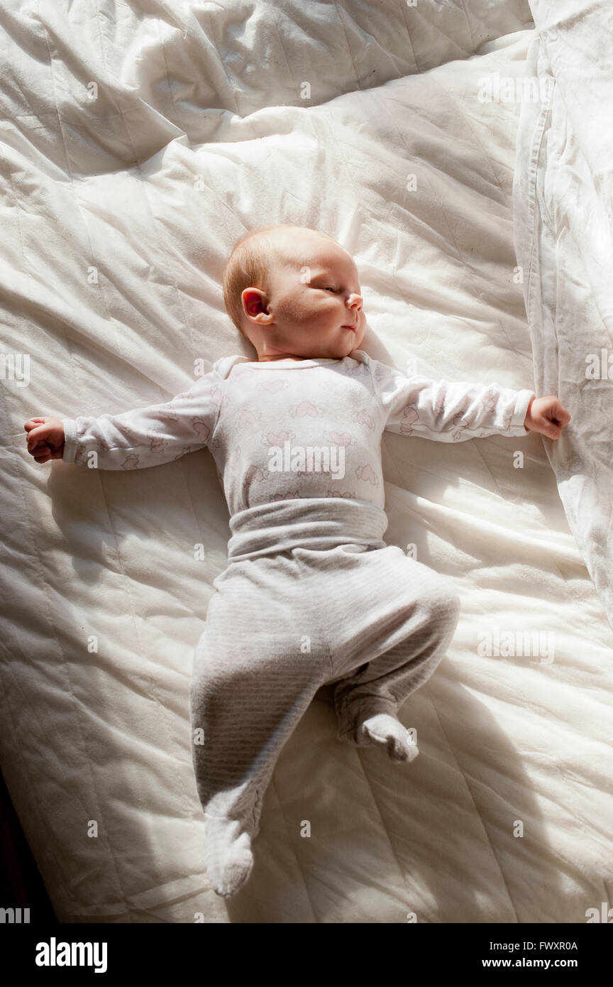 Sweden, Baby girl (25 months) lying down on duvet Stock Photo Alamy