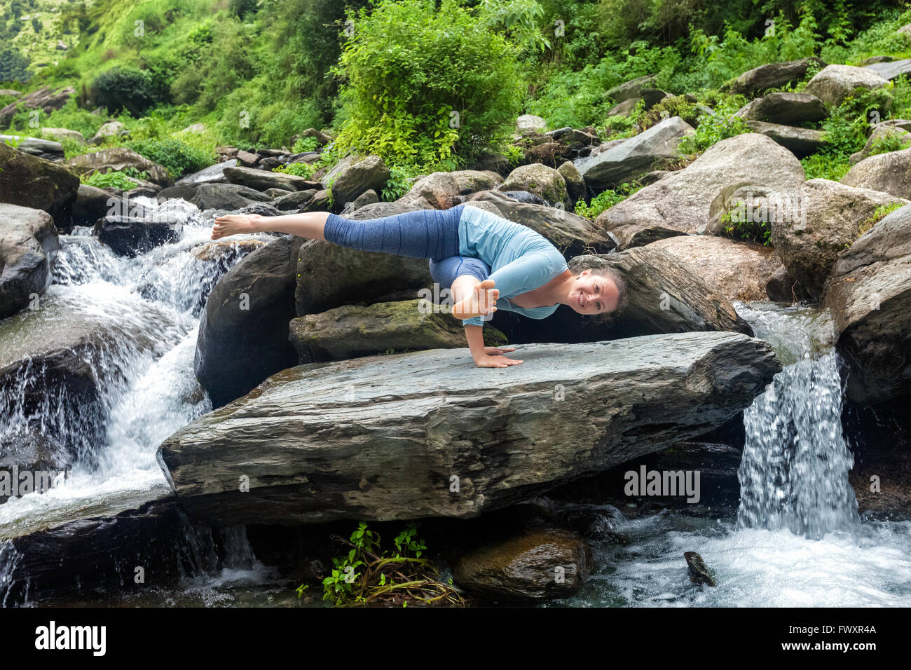 Woman doing yoga oudoors at tropical waterfall Stock Photo - Alamy