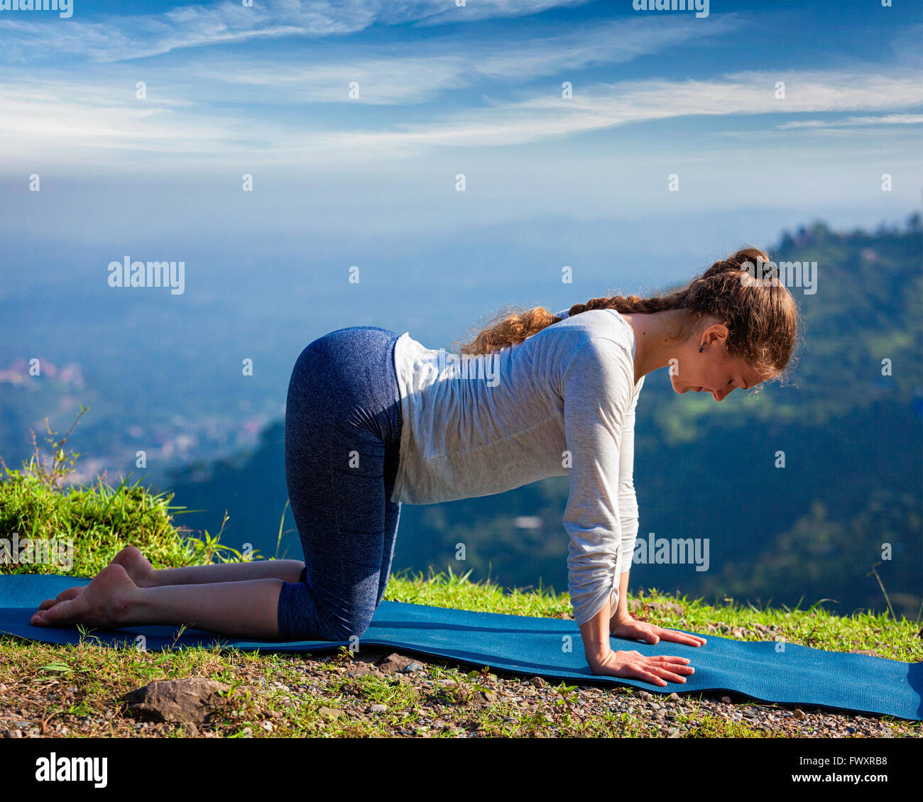 Sporty fit woman practices yoga asana bitilasana outdoors Stock Photo