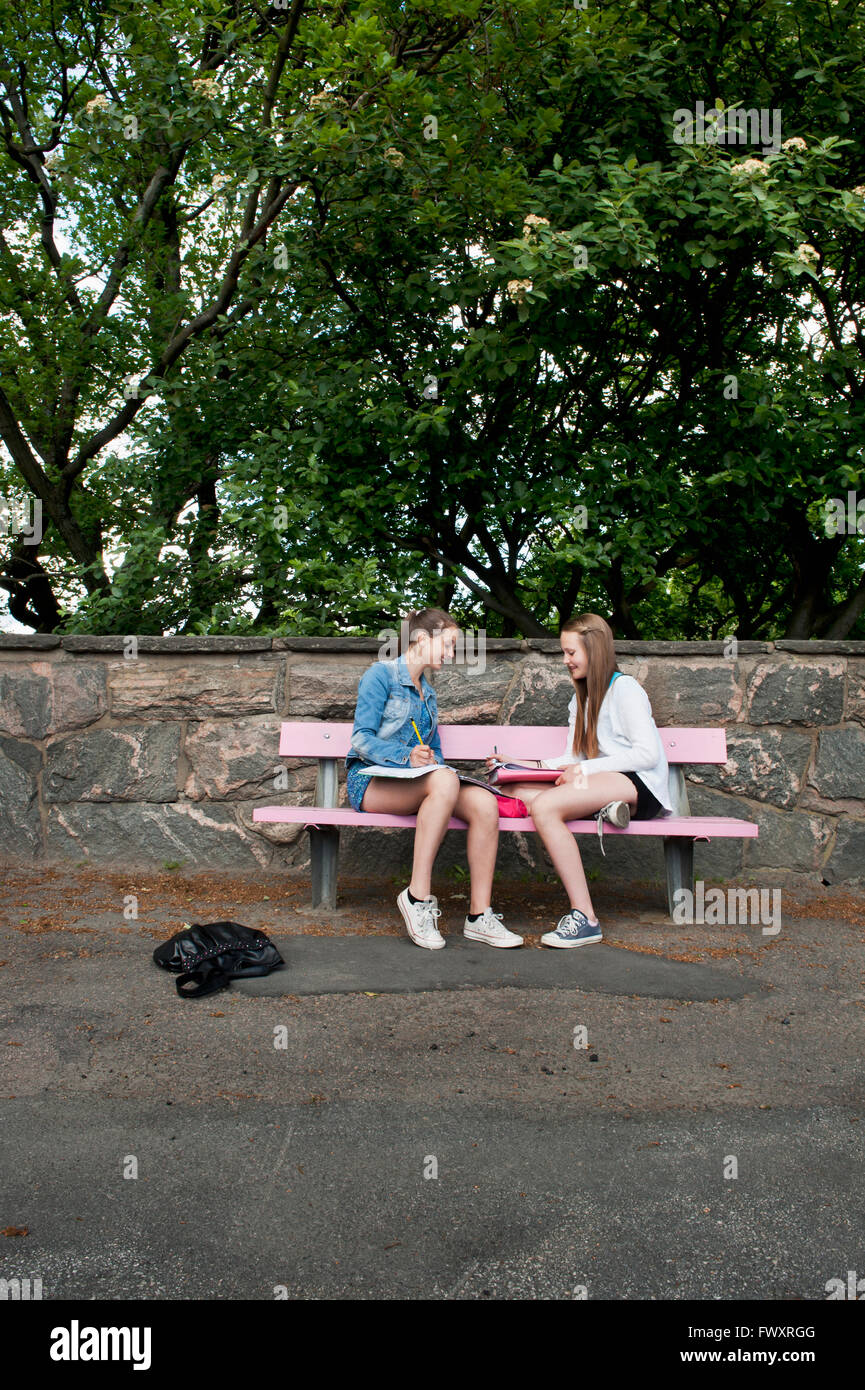 Two girls sitting on park bench hi-res stock photography and images - Alamy