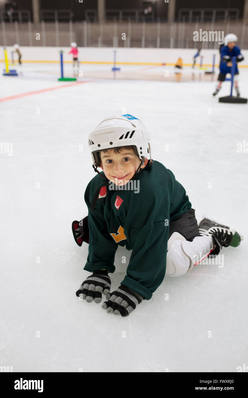Sweden, Young male hockey player (4-5) sitting on ice Stock Photo