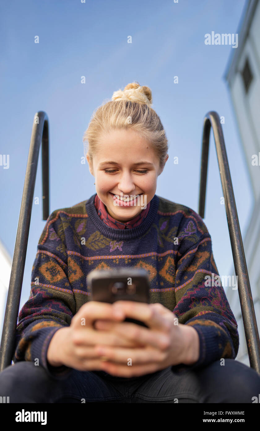 Sweden, Vasterbotten, Umea, Young woman using phone Stock Photo