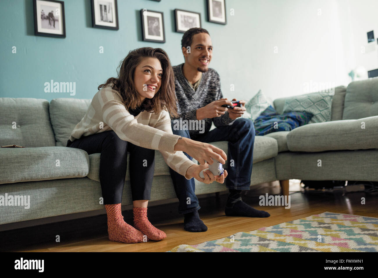 Sweden, Young couple playing video games in living room Stock Photo