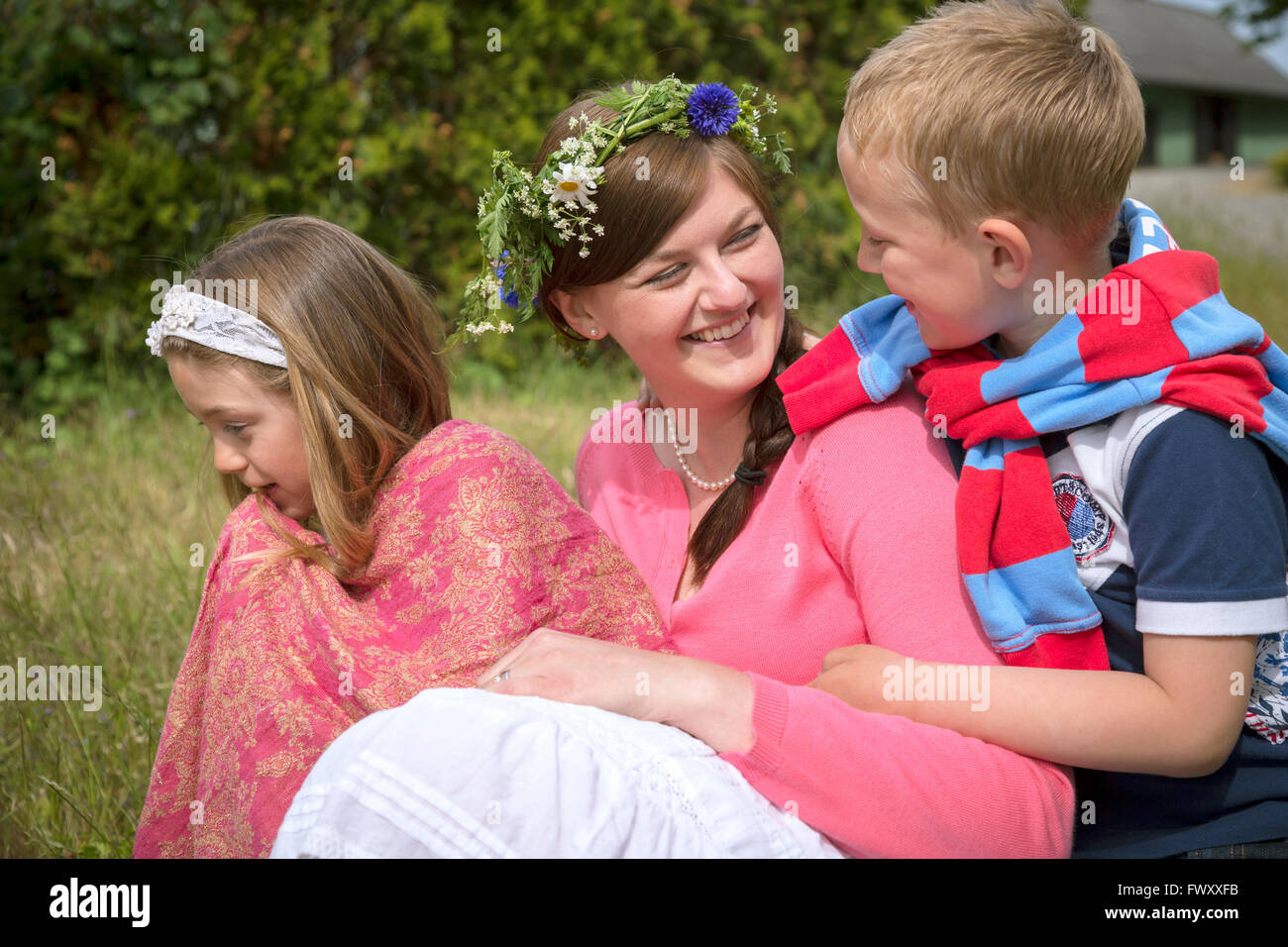 Sweden, Skane, Mother with children (67, 89) during midsummer