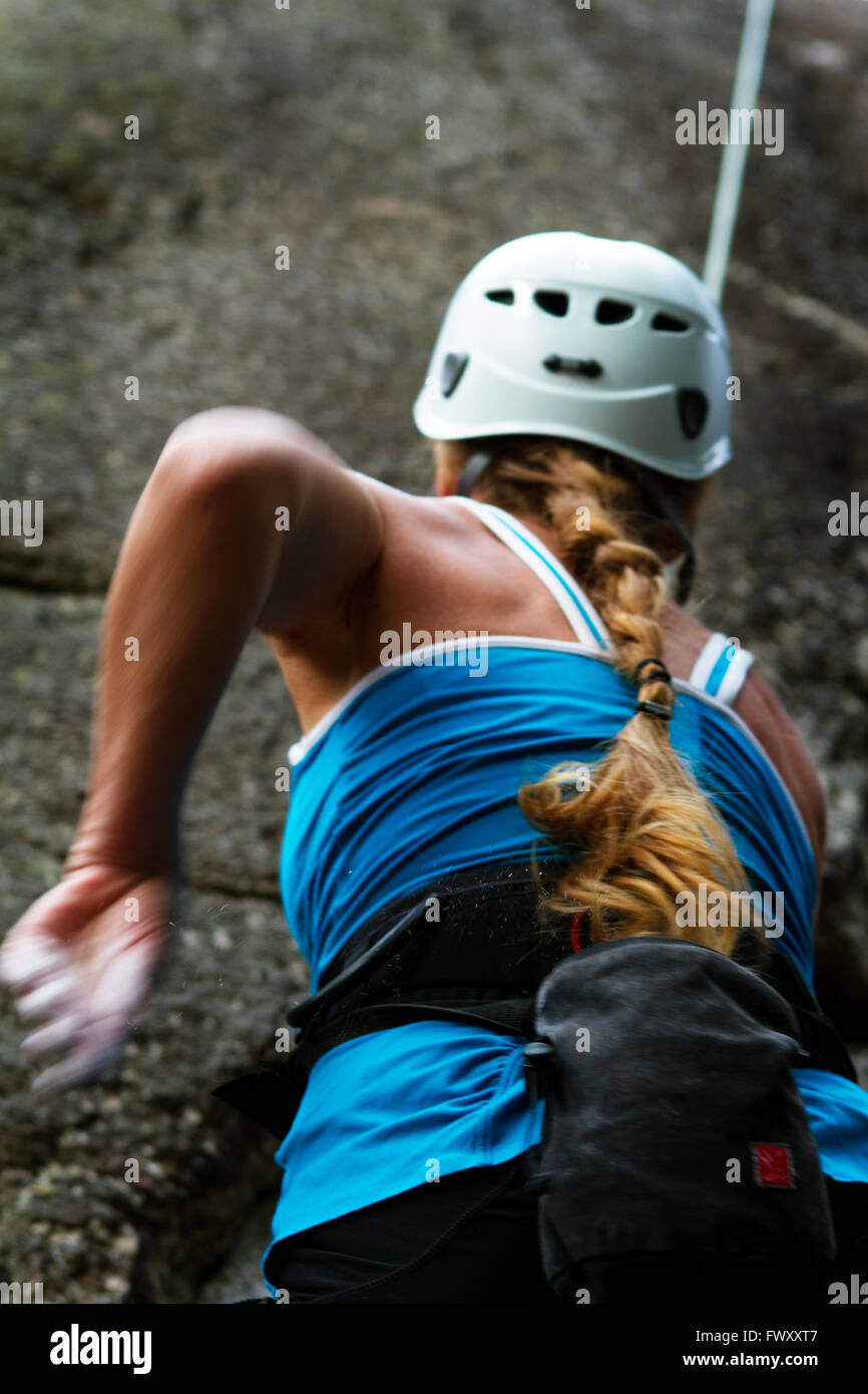 Sweden, Ostergotland, Vaderstad, Rear view of woman climbing rock Stock