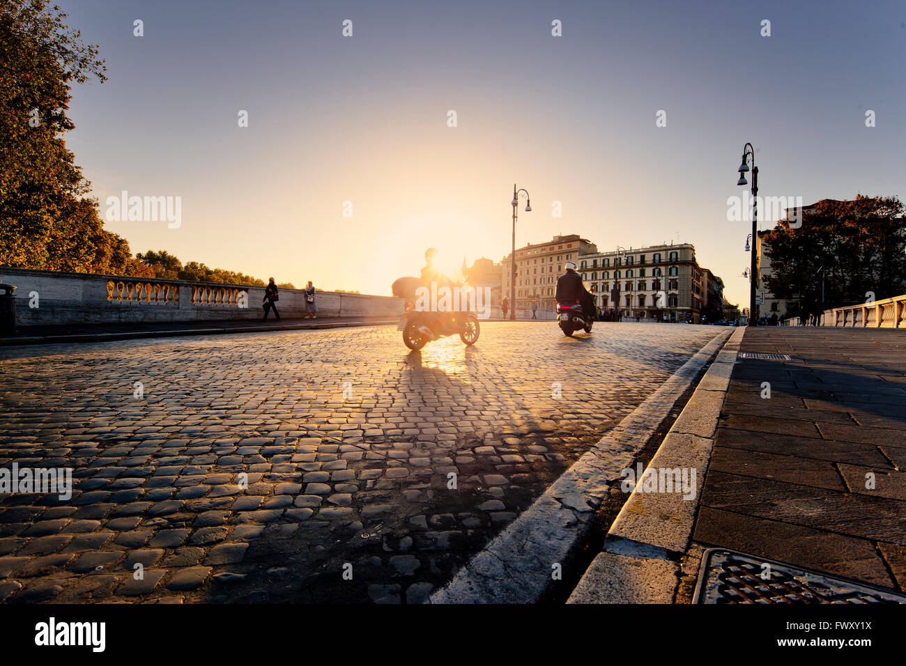 Italy, Rome, Motor scooters on cobblestone street at dusk Stock Photo