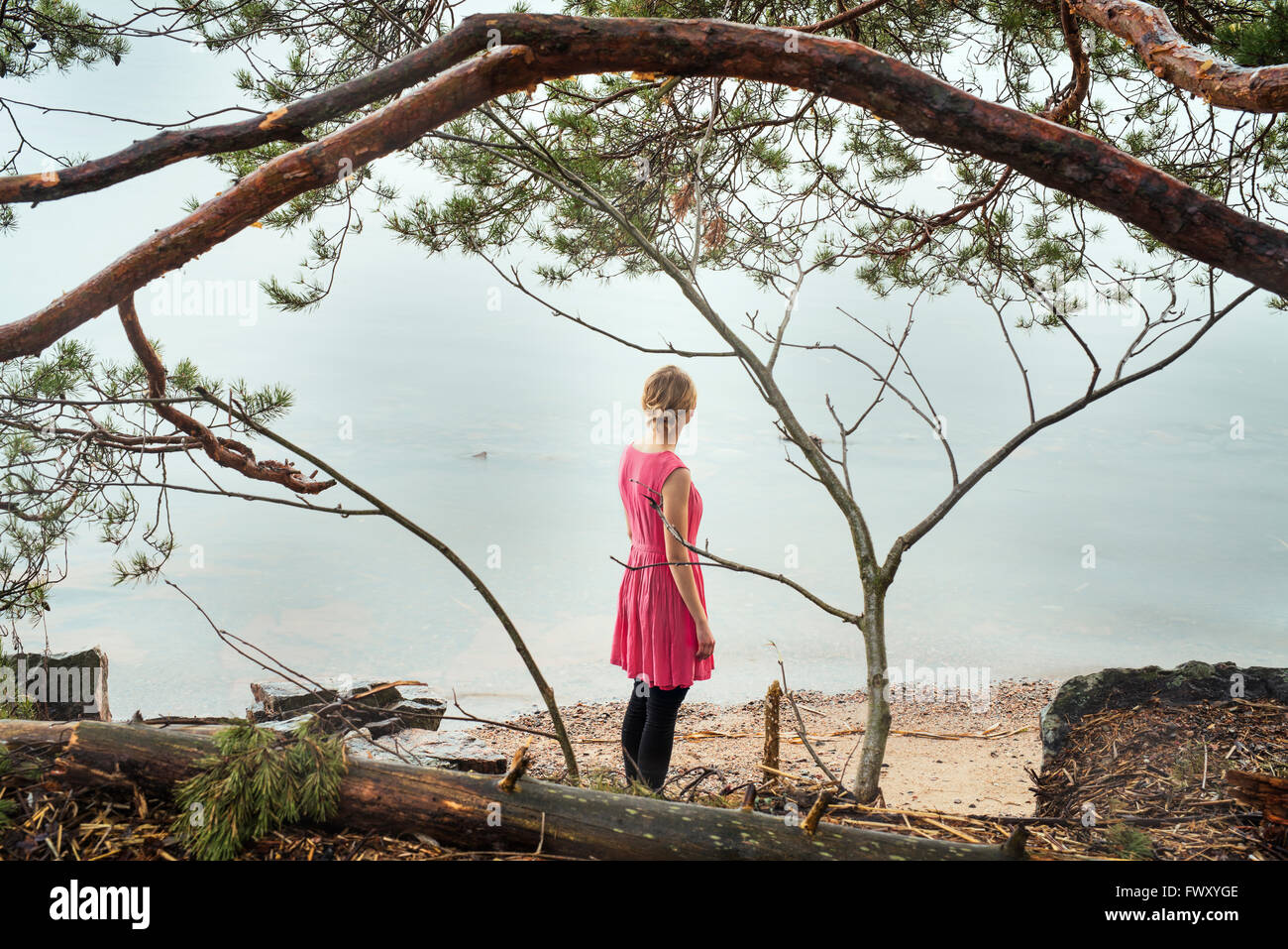 Finland, Varsinais-Suomi, Young woman looking at ocean Stock Photo
