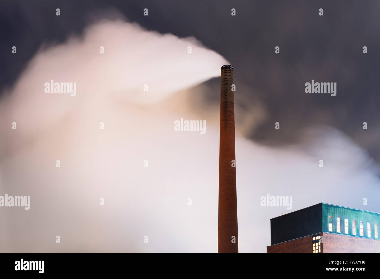 Finland, Pirkanmaa, Smoke coming out of smoke stack at night Stock Photo